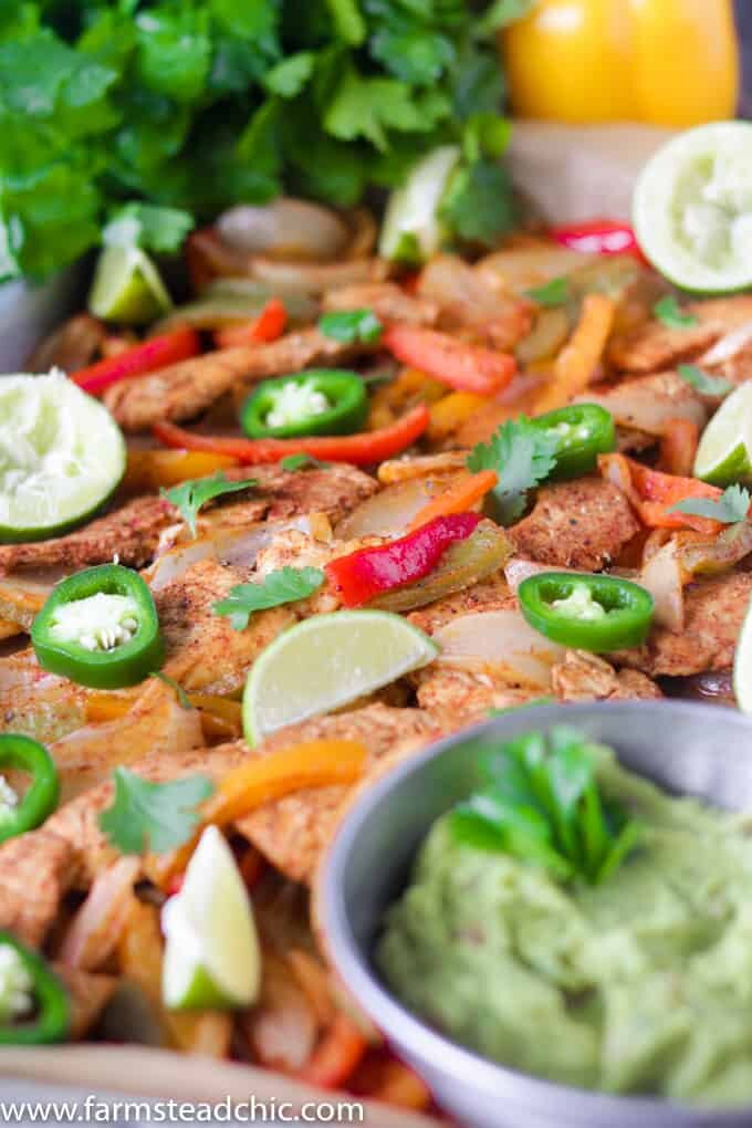 This Paleo and Whole30 Chicken Fajitas Sheet Pan Dinner is simple and easy with minimal cleanup! Serve it with some lime wedges, cilantro and guacamole.