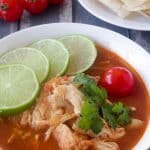 This Paleo and Whole30 Chicken Tortilla Soup is delicious, healthy and so easy to make! Just combine chicken breasts, onion and tomatoes in the slow cooker along with a few common spices like chili powder, garlic and cayenne and you have a scrumptious one pot slow cooker dinner! Garnish with limes, cilantro + avocado!