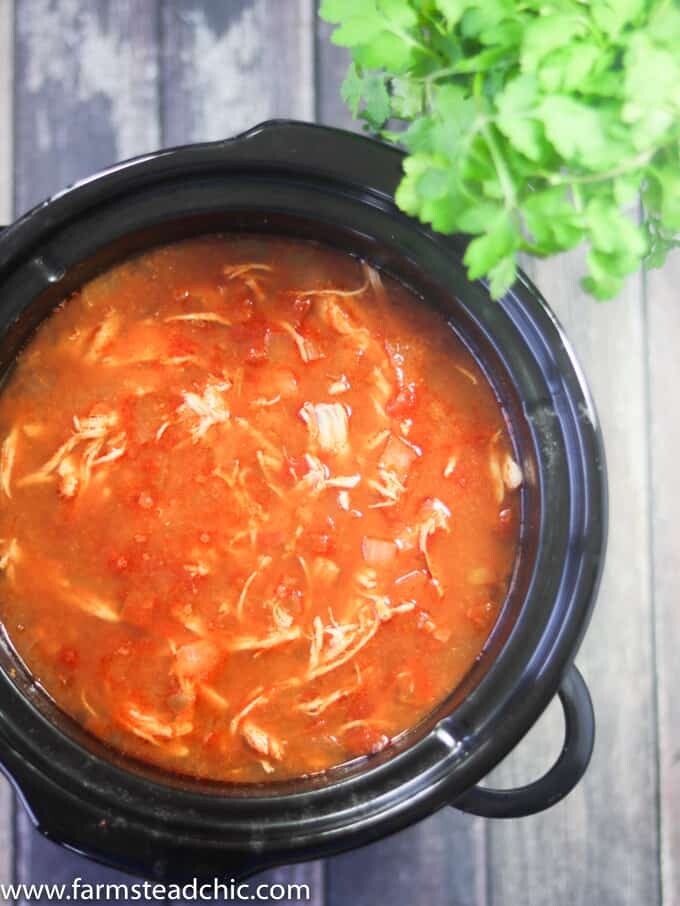 This Paleo and Whole30 Chicken Tortilla Soup is delicious, healthy and so easy to make! Just combine chicken breasts, onion and tomatoes in the slow cooker along with a few common spices like chili powder, garlic and cayenne and you have a scrumptious one pot slow cooker dinner! Garnish with limes, cilantro + avocado! 