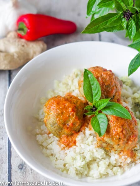 Low Carb, Keto Curry Turkey Meatballs served over cauliflower rice and topped with red curry sauce and fresh Thai basil
