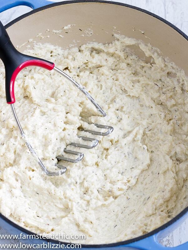 These Low Carb, Keto Mashed Cauliflower Fauxtatoes are super creamy and flavored with plenty of butter, thyme, oregano and garlic. Enjoy them at your next holiday gathering or summer BBQ. They taste like the best-ever garlic herb mashed potatoes with only a fraction of the carbs! #farmsteadchic #ketopotatoes #keto #lowcarb #lowcarbpotatoes #mashedpotatoes #mashedfauxtatoes #fauxtatoes #holidaysidedish #holidaysidedishes #ketosidedish #lowcarbsidedish