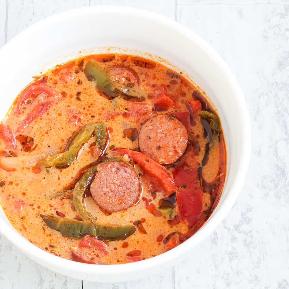 This Low Carb, Keto Sausage and Peppers Soup is full of so many fresh flavors! Crispy-browned beef kielbasa, sweet red and green bell peppers and savory onions simmer in a chicken and tomato-based broth. Freshly minced garlic and Italian seasoning provide plenty of favor, and heavy cream balances out the spiciness of crushed red pepper. #farmsteadchic #lowcarbsoup #ketosoup #sausageandpeppers #creamysoup #kielbasa #sausagesoup